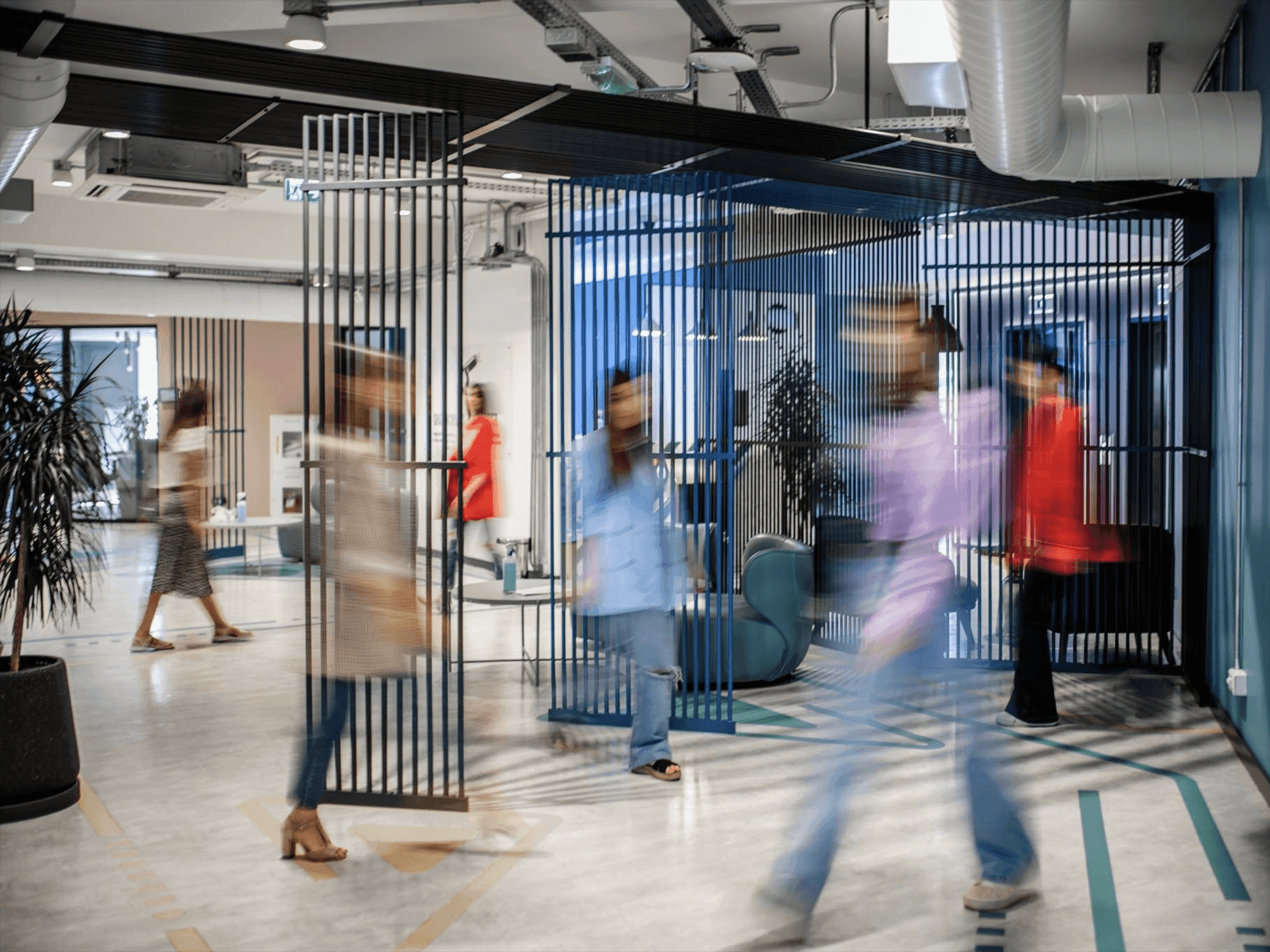 Blurred people moving through a modern, open-plan office with contemporary design.